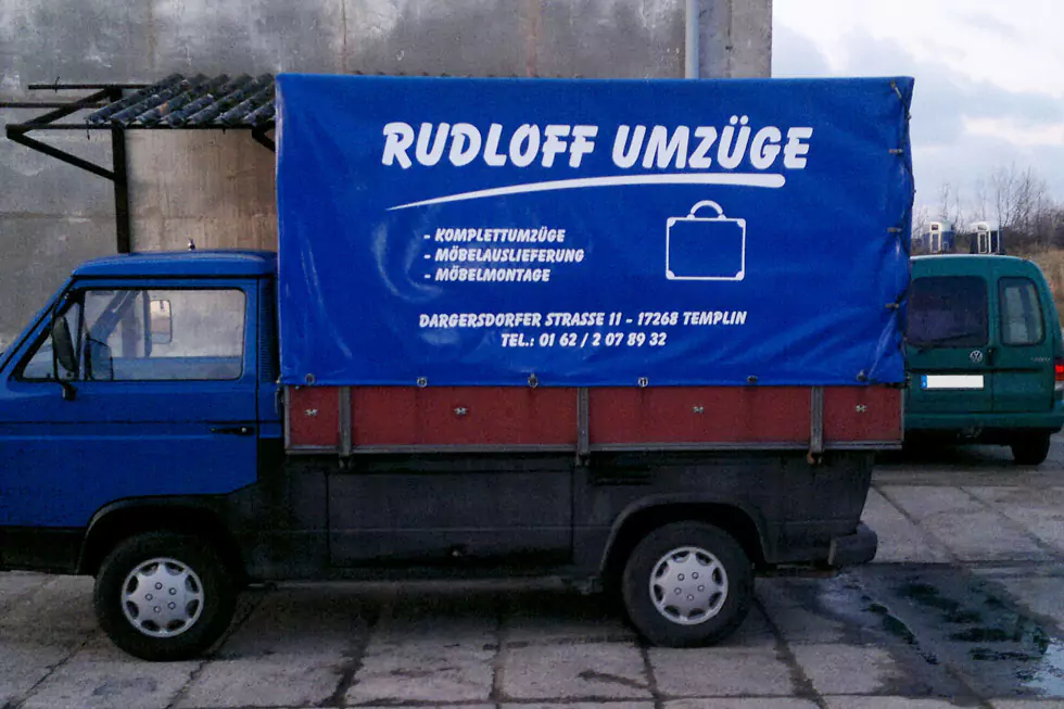 alter blauer Transporter mit Aufschrift Rudloff Umzüge, Adressdaten und Leistungen